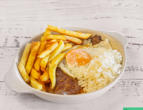 Juicy grilled ribeye steak garnished with fresh rosemary in cast iron skillet.