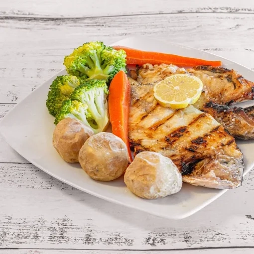 Artistic presentation of seafood with clams and herbs on a white plate.