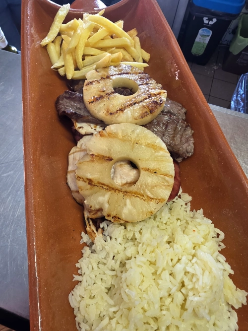 Tantalizing barbecue with various meats and shrimp skewers on the grill outdoors.